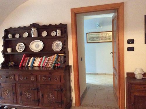 a room with a wooden dresser and a hallway with a door at I "Giardin" in Crissolo