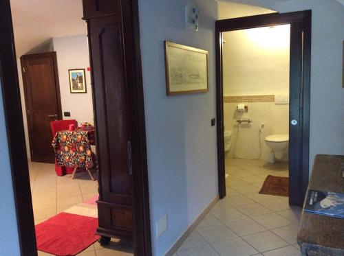 a bathroom with a toilet and a door to a room at I "Giardin" in Crissolo