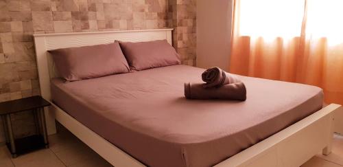 Basic & Cozy Home في بايان ليباس: سرير فيه محفظه تجلس عليه