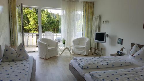 a bedroom with two beds and a table and chairs at Hotel Pension Jägerstieg in Bad Grund