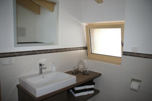 a white bathroom with a sink and a window at Ferienwohnungen Ellen Müller in Fischen