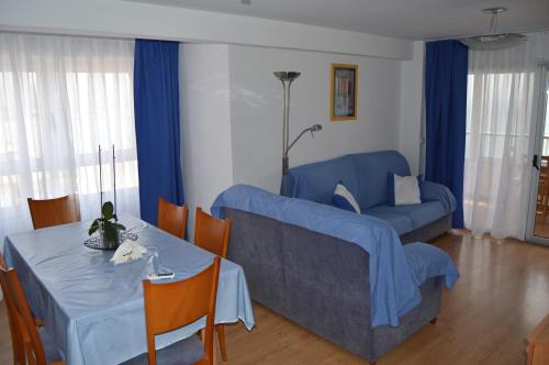 エル・カンページョにあるApartment first line beach El Campello (Alicante)のリビングルーム(青いソファ、テーブル付)