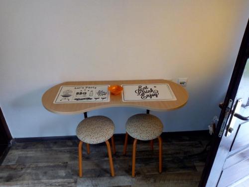 una mesa con dos sillas y una naranja en ella en Apartment Minimal, en Novi Sad