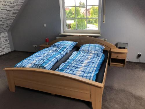 - un lit avec 2 oreillers bleus dans l'établissement FewoJanssen, à Apen