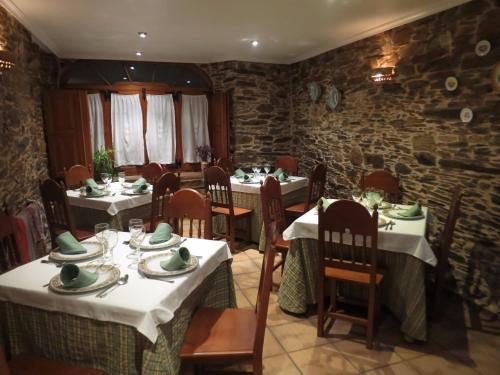 un comedor con mesas y sillas en un restaurante en Casa Benaxo, en Currelos