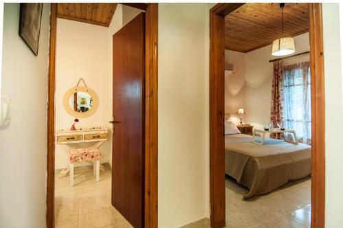 um corredor que leva a um quarto com uma cama e um espelho em Loggos Summer House em Vasilikos