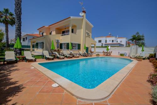 a swimming pool in front of a house at Altura Prime 5 Suite Villa with Private Pool and Parking Walk to Beach in Altura