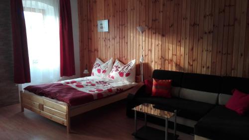 a bedroom with a bed and a couch at Alföldi Vendégház in Hódmezővásárhely