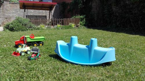 a toy car and a toy truck in the grass at Alföldi Vendégház in Hódmezővásárhely