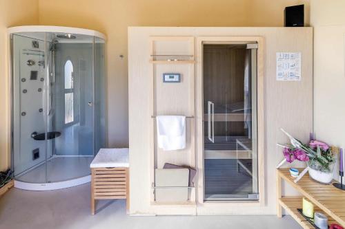 a bathroom with a shower and a glass door at Le Sodole Country Resort & Golf in Pontedera