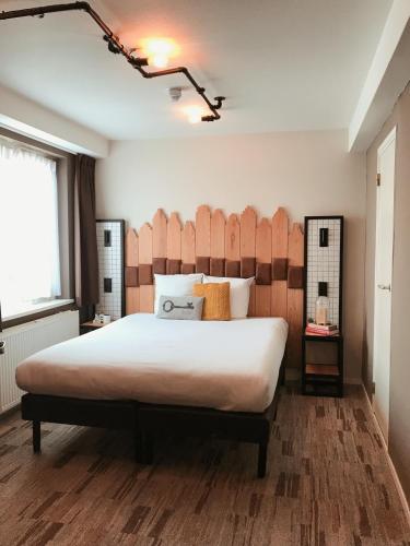 a bedroom with a large bed with a wooden headboard at Mr. Jordaan in Amsterdam