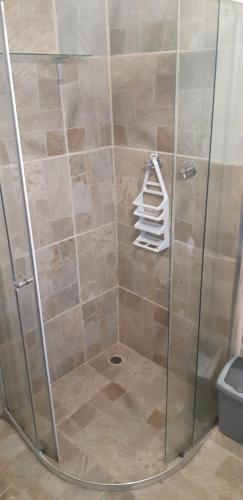 a shower with a glass shower stall with a pile of towels at five fishes coffeebay in Coffee Bay