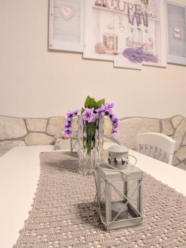 un jarrón de flores púrpuras sentado en una mesa en Tato home, en Alatri
