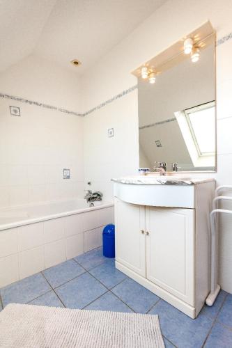 une salle de bain avec un lavabo, une baignoire et un miroir dans l'établissement Résidence Les Hauts du Brouennou, à Landéda
