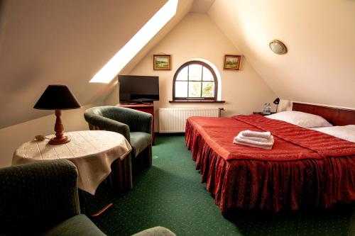 a attic room with a bed and a table and chairs at Willa Victor in Jastrzębia Góra