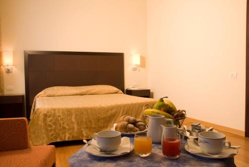 a bedroom with a bed and a table with a tray of fruit at Hotel Terme in Monticelli Terme