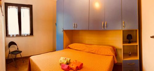 um quarto com uma cama, uma cadeira e armários em appartamento vacanze Sardegna em Siniscola