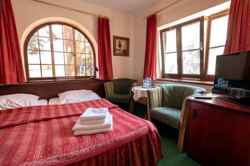 ein Hotelzimmer mit einem Bett und zwei Stühlen in der Unterkunft Willa Victor in Jastrzębia Góra