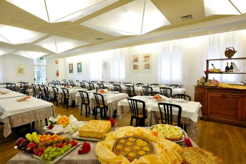 a large room with tables and chairs with food on them at Hotel Terme in Monticelli Terme