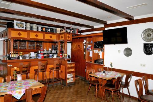 a restaurant with tables and chairs and a bar at Zum Mühlehannes in Rohrbach