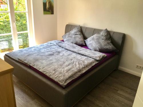 uma cama com almofadas em cima num quarto em Ferienhaus Feel like Home Barbecue em Hamburgo