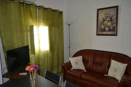 a living room with a couch and a table with a television at Casinha das Flores in Reguengos de Monsaraz