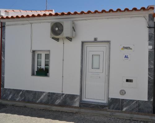 a white building with a door and a window at Casinha das Flores in Reguengos de Monsaraz