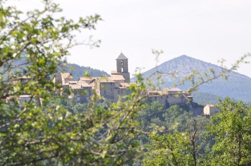 a town on top of a hill with a clock tower at Camping du Moulin de Thoard in Thoard