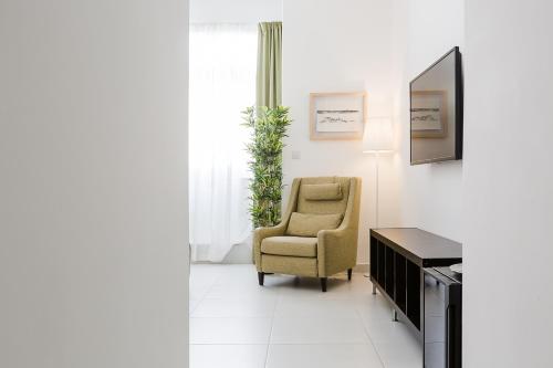 a living room with a chair and a television at Two Pillows Boutique Hostel in Sliema