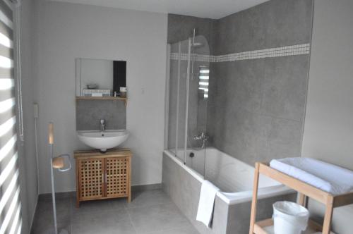 a bathroom with a tub and a sink and a bath tub at Gite Terre de ciel in Ferrières