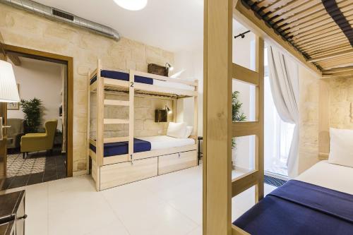 a bedroom with bunk beds and a living room at Two Pillows Boutique Hostel in Sliema