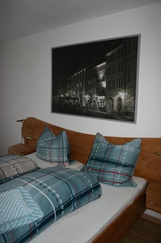 a bed with blue pillows and a picture on the wall at Apartment Rose in Todtmoos