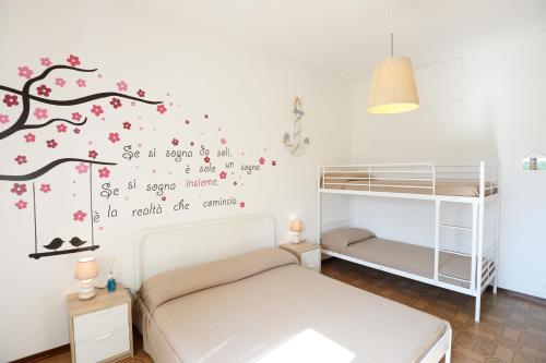 - une chambre avec 2 lits superposés et une fresque murale sur les arbres dans l'établissement Le Palme 98 "Casa Vacanze", à Lido di Camaiore