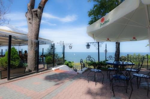 a patio with a table and chairs and the ocean at Willa Victor in Jastrzębia Góra