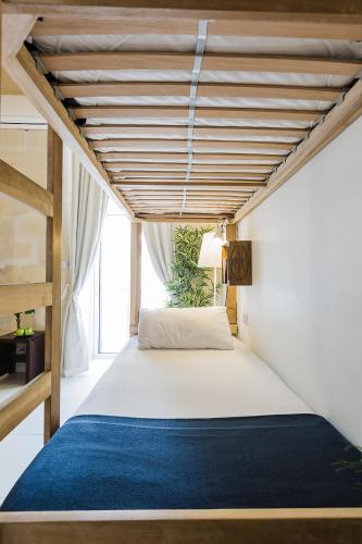 a bedroom with a large bed with a blue rug at Two Pillows Boutique Hostel in Sliema