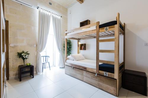 a bedroom with two bunk beds in a room at Two Pillows Boutique Hostel in Sliema