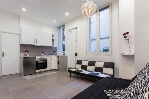 un salon avec un canapé et une cuisine dans l'établissement Le Logis de Montmartre, à Paris