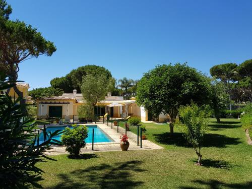 una casa con piscina en un patio en The Pinewood Villa, en Vilamoura