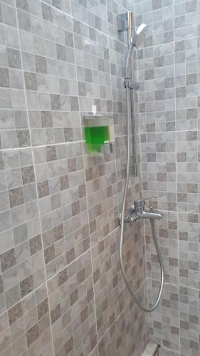 a shower with a hose in a tiled bathroom at Double'A beach house in Nusa Lembongan