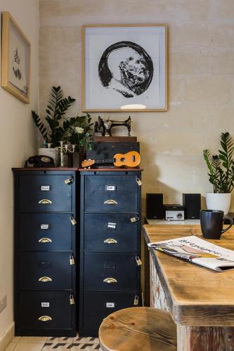 a kitchen with a counter and some drawers and a table at Two Pillows Boutique Hostel in Sliema