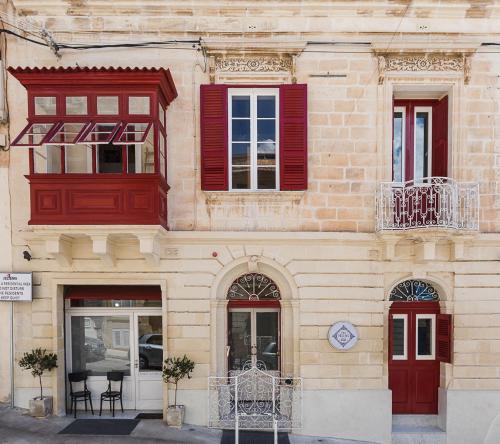 a building with red windows and a clock on it at Two Pillows Boutique Hostel in Sliema