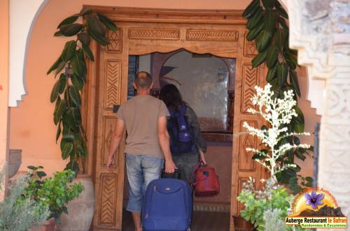 a man and woman walking through a wooden door at Auberge Restaurant le Safran in Taliouine