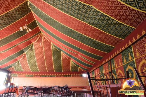 a dining room with a colorful ceiling with tables and chairs at Auberge Restaurant le Safran in Taliouine