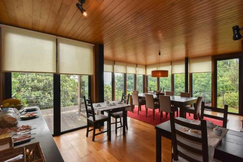 a dining room with tables and chairs and windows at Quinta De Abol De Baixo in Entre-os-Rios