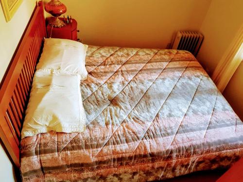 a bedroom with a bed with a quilt on it at Duplex elegante Dois Quartos Em Gramado in Gramado