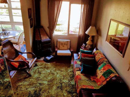 uma sala de estar com um sofá e uma janela em Duplex elegante Dois Quartos Em Gramado em Gramado