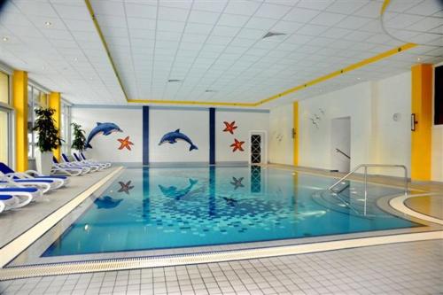 a swimming pool with dolphins painted on the wall at Haus Christoph in Maria Alm am Steinernen Meer