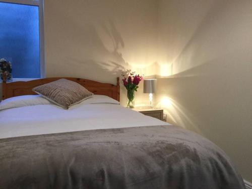 a bedroom with a bed and a vase of flowers on a table at Rose Alley Apartment in Westport