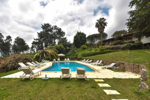 a pool with chaise lounge chairs and a bunch ofvisorvisor at Quinta De Abol De Baixo in Entre-os-Rios