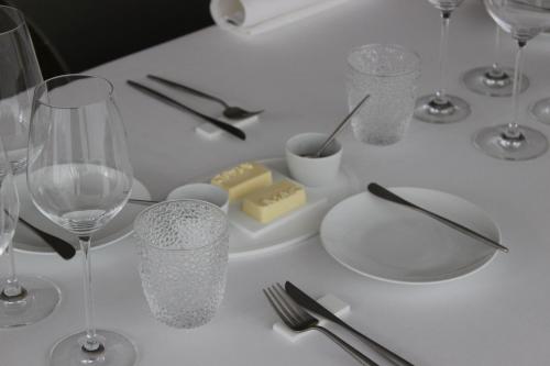 a white table with wine glasses and utensils on it at MAIO B&B en Dinner in Zonhoven